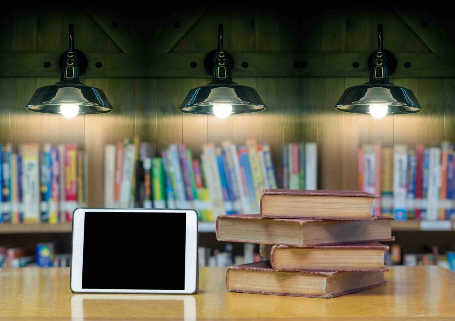 old book on the desk in library with tablet and Luxury lighting decoration